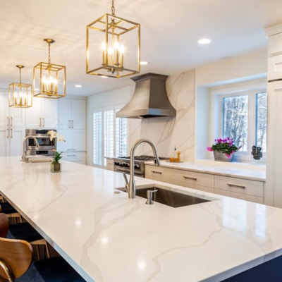 The large kitchen island is lighted by three geometic gold lights