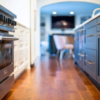 The island's dark blue cabinets contrast nicely against the stainless steel appliances and cabinet hardware